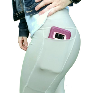 side view of a pocket legging beige color with a phone coming out
